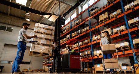 low-angle-view-happy-warehouse-workers-communicating-while-working-with-shipment-industrial-storage-compartment_637285-4208